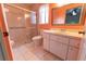 Bright bathroom features white vanity with sink, framed mirror, toilet, and glass-enclosed shower at 6150 Sw 103Rd Loop, Ocala, FL 34476