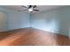 This spacious bedroom features wood flooring, a ceiling fan, and light blue walls at 6150 Sw 103Rd Loop, Ocala, FL 34476
