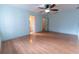 This spacious bedroom features wood flooring, a ceiling fan, and access to a walk in closet at 6150 Sw 103Rd Loop, Ocala, FL 34476