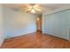 Bedroom features a ceiling fan, wood floor and a closet with blue doors at 6150 Sw 103Rd Loop, Ocala, FL 34476