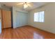 Bedroom features a ceiling fan, wood floor and a closet with blue doors at 6150 Sw 103Rd Loop, Ocala, FL 34476