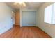 Bedroom features a ceiling fan, wood floor and a closet with blue doors at 6150 Sw 103Rd Loop, Ocala, FL 34476