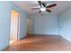 This spacious bedroom features wood flooring, a ceiling fan, and three doors at 6150 Sw 103Rd Loop, Ocala, FL 34476