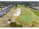 Aerial view showcasing a golf course community with sand traps, green, and well-maintained homes at 6816 Sw 95Th Cir, Ocala, FL 34481