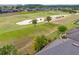 View from above showing a golf course with trees and a large sand trap in a residential neighborhood at 6816 Sw 95Th Cir, Ocala, FL 34481