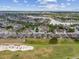 Wide aerial view of a residential community surrounding a golf course and a serene lake at 6816 Sw 95Th Cir, Ocala, FL 34481
