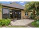Outdoor patio area with sliding glass doors, adorned with tropical plants, for seamless indoor-outdoor living at 6816 Sw 95Th Cir, Ocala, FL 34481