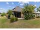 Exterior of home with a paver patio, tropical plants, and well-manicured lawn, creating an inviting outdoor space at 6816 Sw 95Th Cir, Ocala, FL 34481
