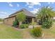 Landscaped backyard featuring a paver patio, tropical plants, and lush lawn, perfect for outdoor entertaining at 6816 Sw 95Th Cir, Ocala, FL 34481
