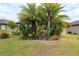 Well-maintained backyard with lush tropical plants surrounding the home, creating a private outdoor oasis at 6816 Sw 95Th Cir, Ocala, FL 34481