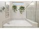 Bathroom featuring a tiled soaking tub, decorative greenery, and chrome fixtures at 6816 Sw 95Th Cir, Ocala, FL 34481
