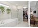 Bathroom showcasing a walk-in closet, bathtub, shower with glass door, and stylish finishes at 6816 Sw 95Th Cir, Ocala, FL 34481