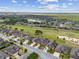 Wide aerial view of a Gathering-friendly community featuring a golf course with a lake and vast field at 6816 Sw 95Th Cir, Ocala, FL 34481