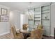 Dining room with a glass-top table, four chairs, a chandelier, and custom shelving along the back wall at 6816 Sw 95Th Cir, Ocala, FL 34481