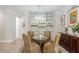 Dining room with a glass-top table, four chairs, a chandelier, and custom shelving along the back wall at 6816 Sw 95Th Cir, Ocala, FL 34481