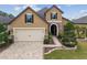 Charming two-story home featuring a brick driveway, manicured lawn, and stone accents on the facade at 6816 Sw 95Th Cir, Ocala, FL 34481
