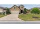 Two-story home featuring a brick driveway, manicured lawn, and stone accents on the facade at 6816 Sw 95Th Cir, Ocala, FL 34481