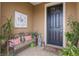 Comfortable front porch with a dark front door, bench seating and decorative plants at 6816 Sw 95Th Cir, Ocala, FL 34481