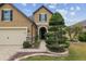 Home's facade with stone archway, manicured shrubs, and paver walkway enhance this house's curb appeal at 6816 Sw 95Th Cir, Ocala, FL 34481
