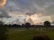 Expansive view of the golf course under a dramatic, cloud-filled sky at sunset at 6816 Sw 95Th Cir, Ocala, FL 34481