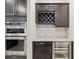 Kitchen area features stainless steel ovens, dark wood cabinets, a wine rack, and a beverage cooler at 6816 Sw 95Th Cir, Ocala, FL 34481