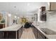 Open concept kitchen featuring granite countertops, stainless steel appliances, modern light fixtures, and dark wood cabinets at 6816 Sw 95Th Cir, Ocala, FL 34481