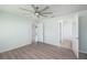 Spacious bedroom with wood floors, ceiling fan, and views into the ensuite bathroom at 7249 Sw 93Rd Ave, Ocala, FL 34481