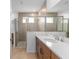 Modern bathroom with walk-in shower, double vanity, and neutral tile design at 7827 Sw 56Th Pl, Ocala, FL 34474