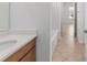 Bathroom vanity with white countertops, wood cabinets, and a view of a hallway at 7827 Sw 56Th Pl, Ocala, FL 34474