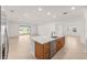 Kitchen island featuring a sink and wooden cabinets, overlooking a large living area at 7827 Sw 56Th Pl, Ocala, FL 34474
