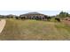 Expansive backyard with green lawn, black metal fence, patio with furniture, and perimeter landscaping at 9063 Sw 59Th Lane Rd, Ocala, FL 34481