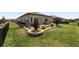 This backyard features a green lawn, manicured landscaping, a patio, and a secure black metal fence at 9063 Sw 59Th Lane Rd, Ocala, FL 34481