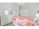 A bright bedroom featuring gray walls, a large dresser with mirror, and a bed with colorful patchwork quilt at 9063 Sw 59Th Lane Rd, Ocala, FL 34481
