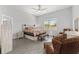 Bright bedroom featuring wood floors, ceiling fan and decoratively furnished seating area and foot bench at 9063 Sw 59Th Lane Rd, Ocala, FL 34481
