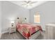 Bright bedroom featuring a ceiling fan, stylish bedside table, and a cozy bed with a colorful patchwork quilt at 9063 Sw 59Th Lane Rd, Ocala, FL 34481