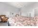 Bright bedroom featuring wood floors, floral bedding set and wicker seating area at 9063 Sw 59Th Lane Rd, Ocala, FL 34481