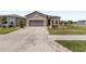 Charming home showcasing a driveway leading to a two-car garage and manicured front yard at 9063 Sw 59Th Lane Rd, Ocala, FL 34481