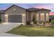 Charming front exterior with a manicured lawn, bay window, and a gray two car garage door at 9063 Sw 59Th Lane Rd, Ocala, FL 34481