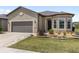 Charming front exterior with a manicured lawn, bay window, and a gray two car garage door at 9063 Sw 59Th Lane Rd, Ocala, FL 34481