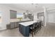 Modern kitchen boasts gray cabinetry, stainless steel appliances, and a large island with seating at 9063 Sw 59Th Lane Rd, Ocala, FL 34481