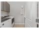 Laundry room with new appliances, gray cabinets, white door, and light tile flooring at 9063 Sw 59Th Lane Rd, Ocala, FL 34481
