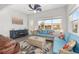Bright Florida room with modern ceiling fan, blue couches, decorative rug, and lots of natural light at 9063 Sw 59Th Lane Rd, Ocala, FL 34481