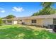 Green backyard with exterior of house, windows, and mature trees in the background at 9333 Sw 97Th Pl # C, Ocala, FL 34481