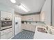 Bright kitchen with white cabinets and appliances, decorative border, and view into the living room at 9333 Sw 97Th Pl # C, Ocala, FL 34481
