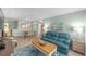 Cozy living room with a teal sofa, wood-look floors, and bright natural light at 9333 Sw 97Th Pl # C, Ocala, FL 34481