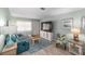 Comfortable living room with a teal sofa, entertainment center, and tropical-themed accents at 9333 Sw 97Th Pl # C, Ocala, FL 34481
