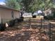Fenced backyard with open gate, and view of neighboring home across the street at 9896 Sw 61St Ct, Ocala, FL 34476