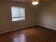 Bedroom with hardwood floors, fan, and window providing natural light at 9896 Sw 61St Ct, Ocala, FL 34476