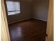 Cozy bedroom featuring hardwood floors and a window with blinds for natural light at 9896 Sw 61St Ct, Ocala, FL 34476