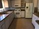 Bright kitchen with white appliances, tiled floor, and ample cabinetry for practical storage at 9896 Sw 61St Ct, Ocala, FL 34476